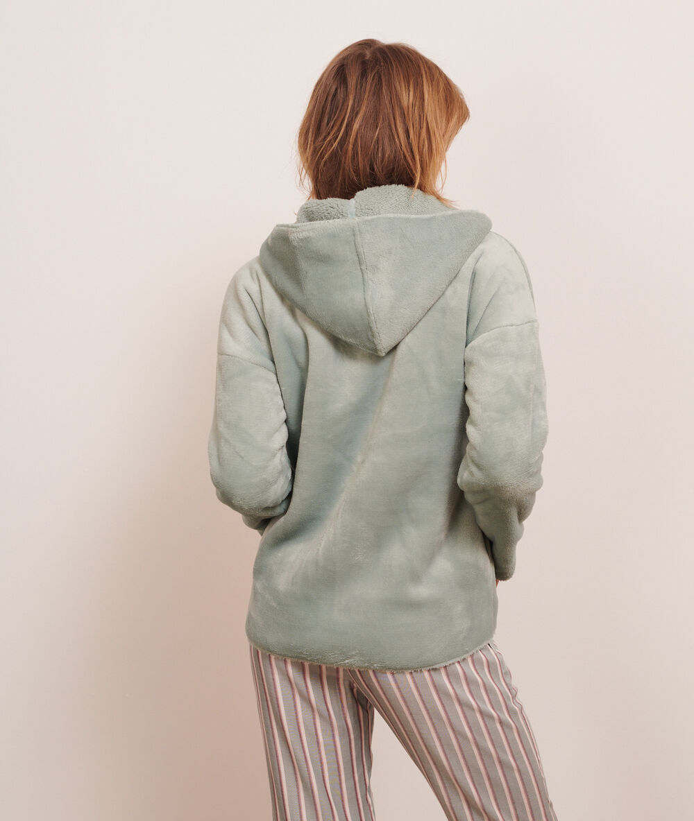 Chaqueta forro polar con capucha verde.